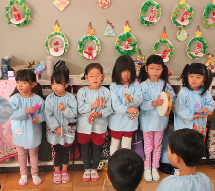 4歳児が鈴やトライアングル、タンバリンを鳴らして遊んでいるところ