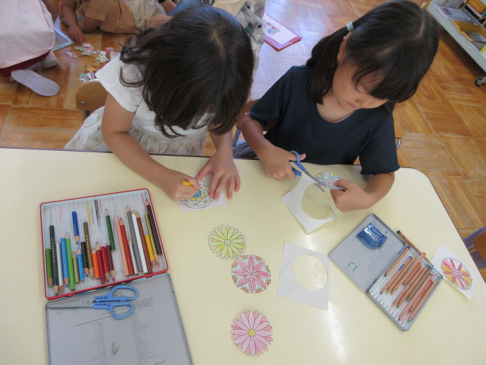 5歳児が塗り絵をしたり紙をハサミで切ったりしているところ