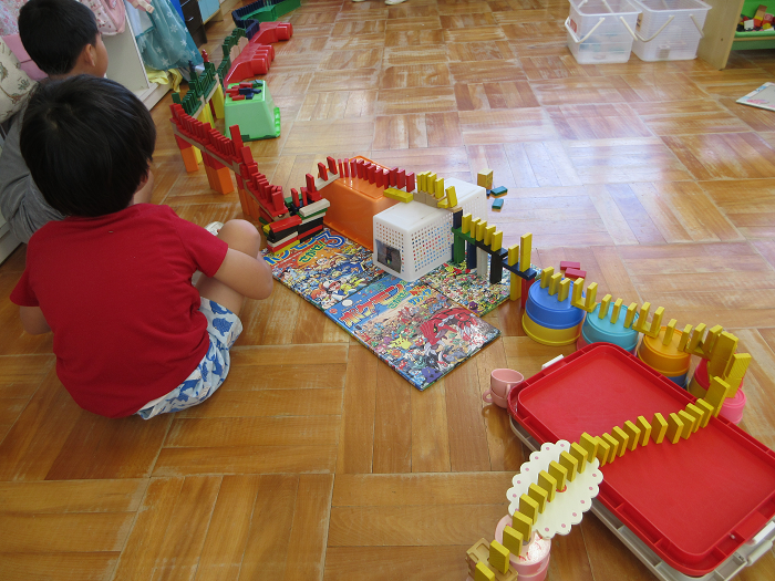 5歳児が友達と協力してドミノコースをつくって遊んでいるところ