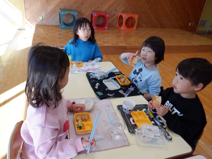 友達と楽しそうに話しながら宅配弁当を食べている5歳児