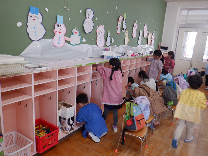 4歳児が、保育室の自分のロッカーを拭き掃除している場面