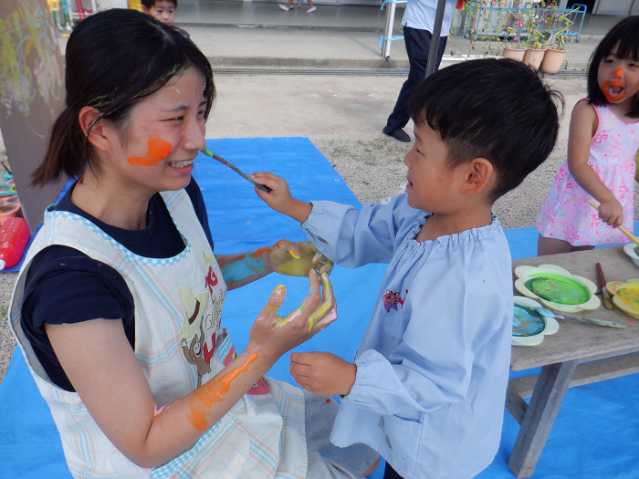 顔に絵具をぬっている子どもの様子