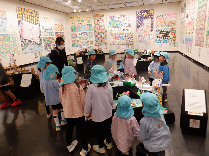 プラスチックで作った人形やおうちなどの作品を友達と一緒に見ている様子