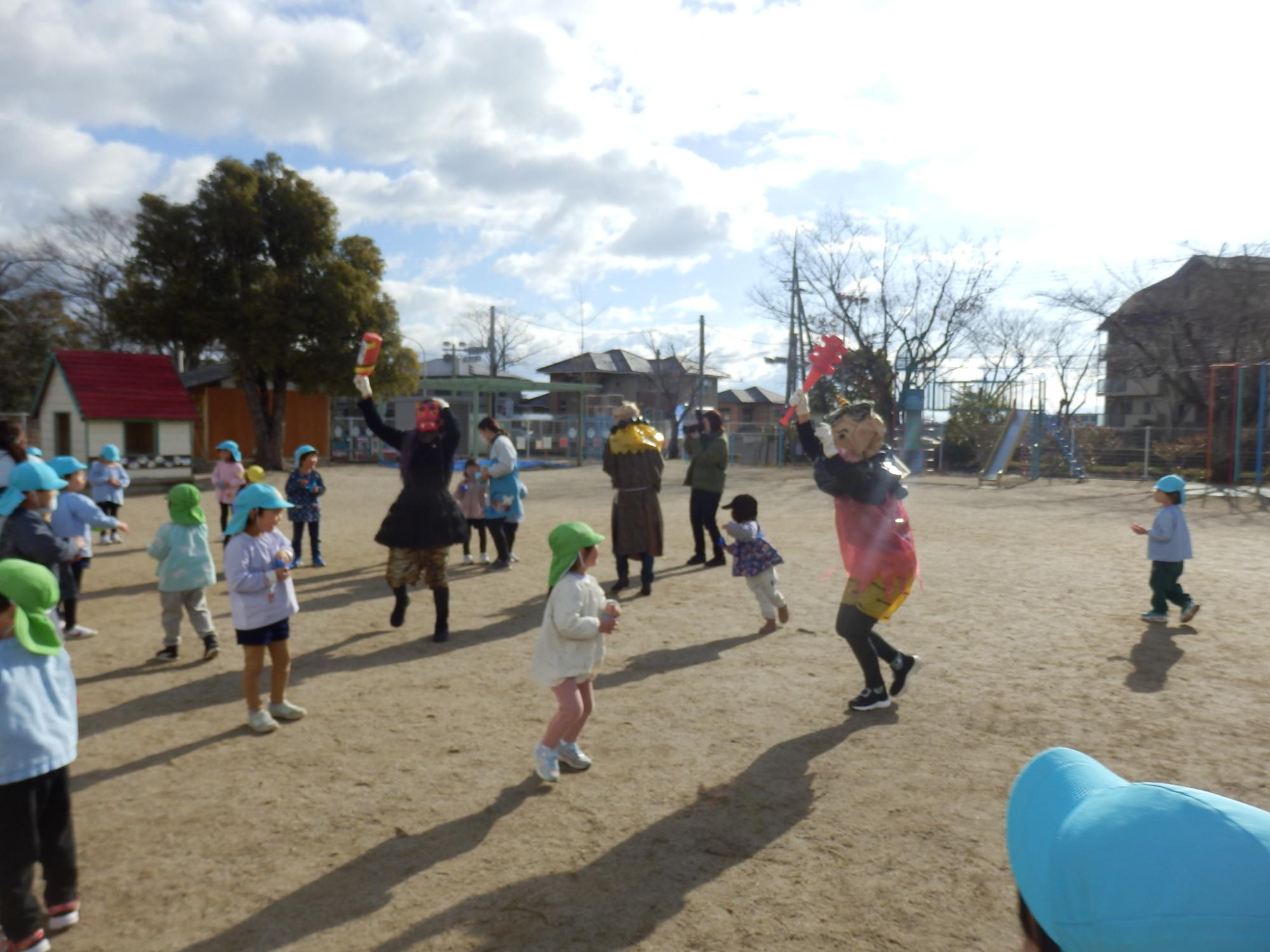 鬼に扮した大人が、園児たちに豆を投げつけられている