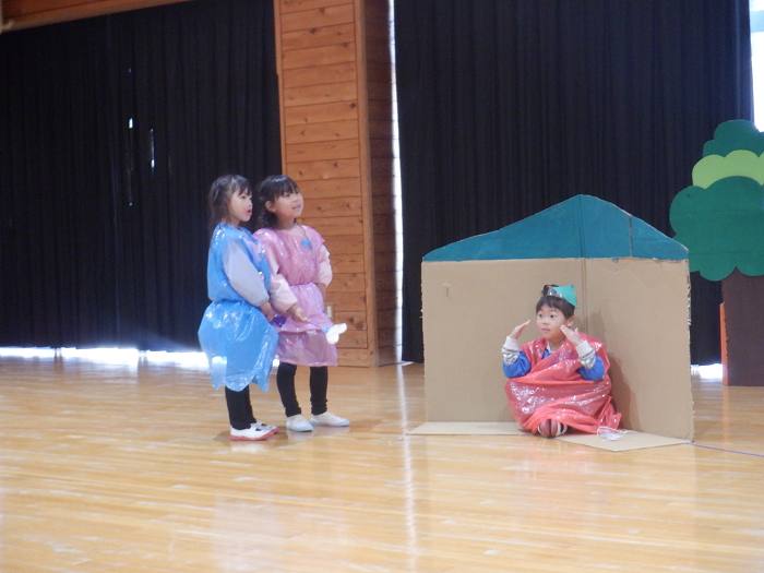 劇の衣装を着て友達と言葉を交わしている5歳児