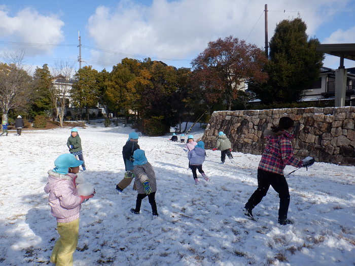 先生や友達と雪合戦をしている5人の5歳児
