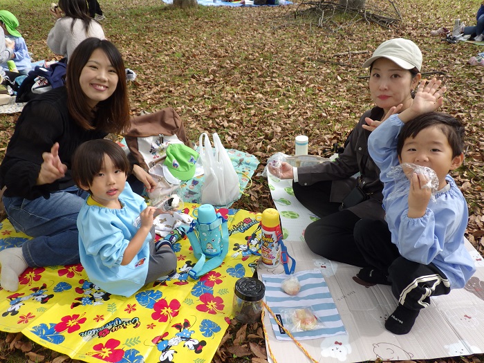 親子遠足でおにぎりを食べる親子の様子