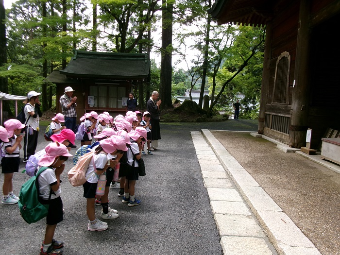 比叡山延暦寺の文殊楼の前で子どもたちが手を合わせてお参りしている様子