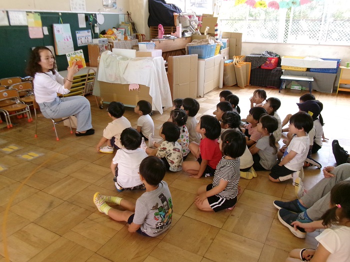 子どもたちが読み聞かせサークルの保護者の方に絵本を読んでもらっている様子