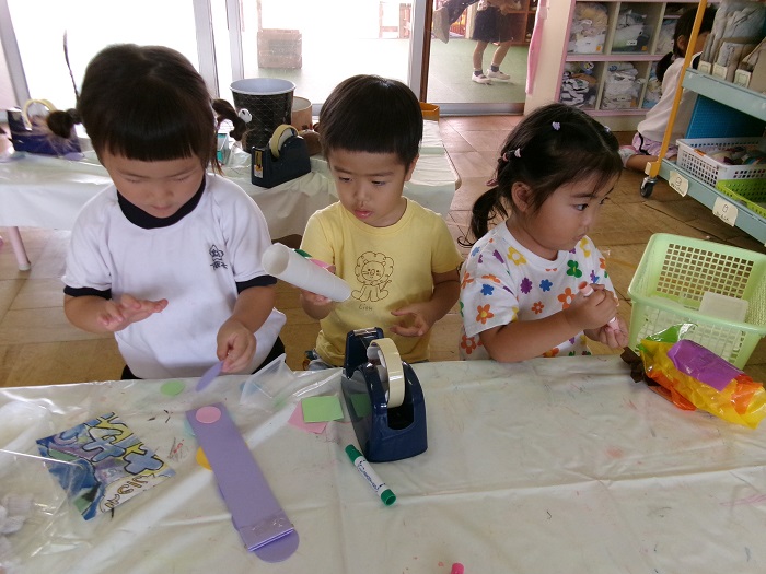 3人の子どもが製作遊びをしている様子