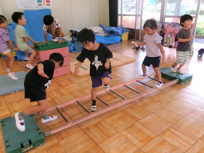 子どもたちが巧技台で運動遊びをして遊んでいるところ