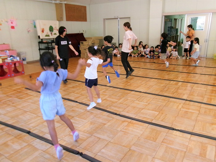 子どもたちと教師がリズムジャンプをして遊んでいるところ