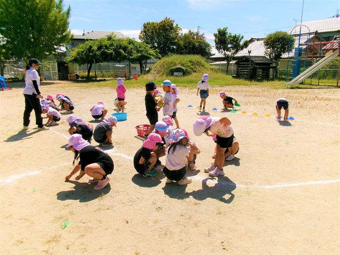子どもたちが園庭の石拾いをしているところ