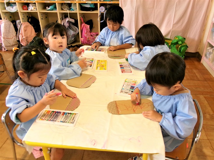 子どもたちが製作遊びでどんぐりをつくっているところ