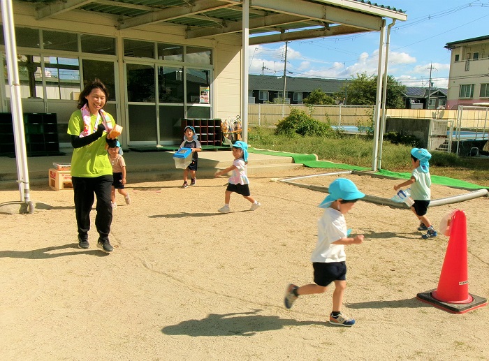 子どもと教師がかけっことをして遊んでいるところ