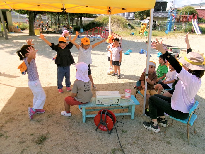 子どもたちと教師が踊りを踊ったり、お客さんになって見ている様子