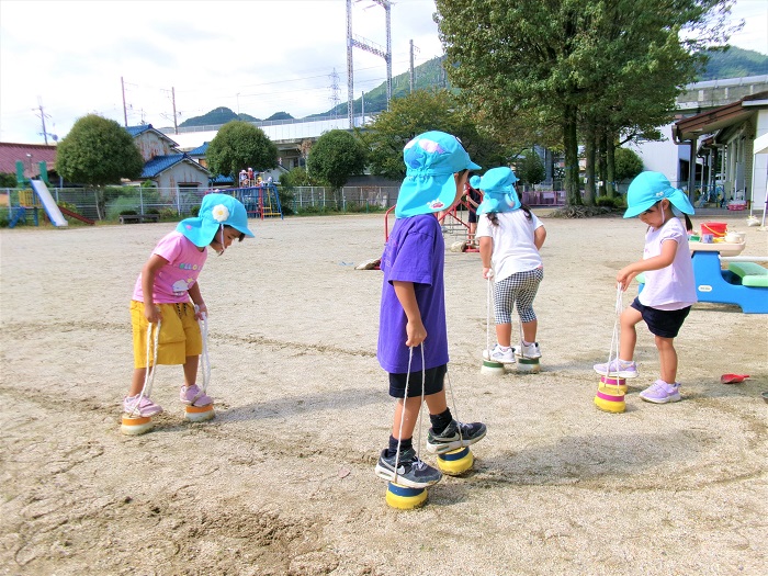 子どもたちがぽっくりに乗って遊んでいる様子
