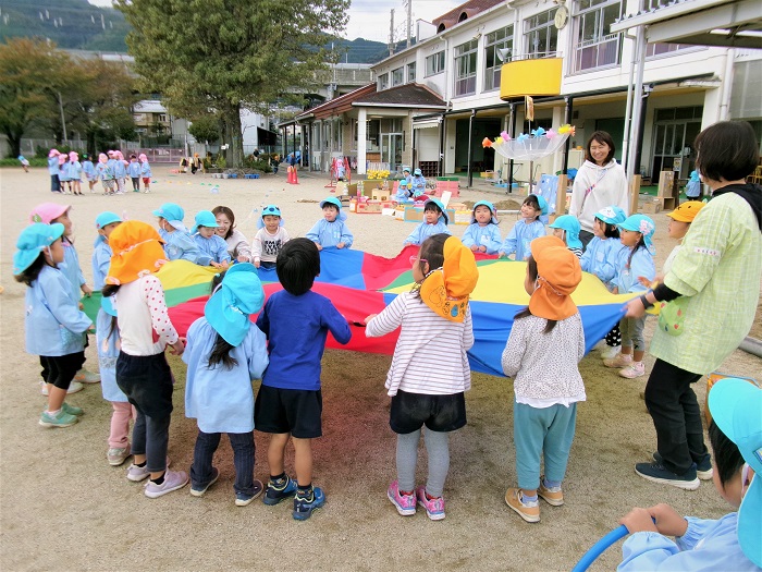 子どもたちと教師がパラバルーン遊びをしている様子