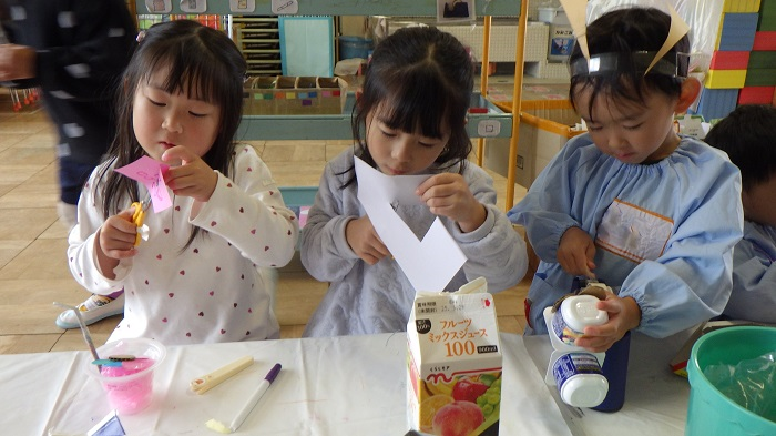 3人の子どもたちが製作遊びをしている様子