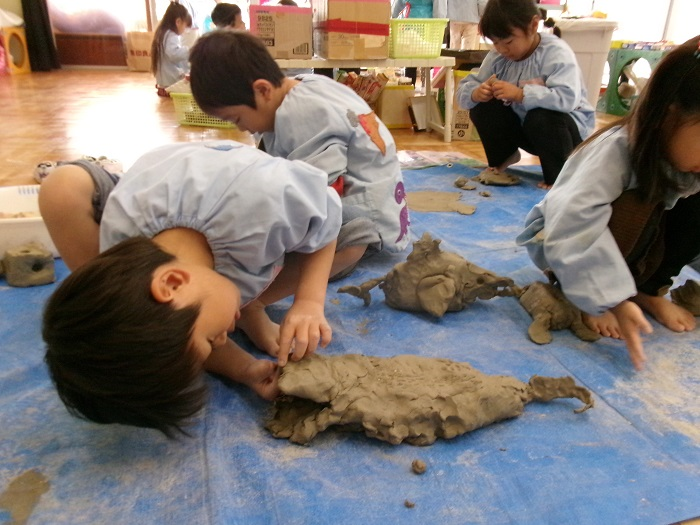 土粘土でワニをつくっている様子