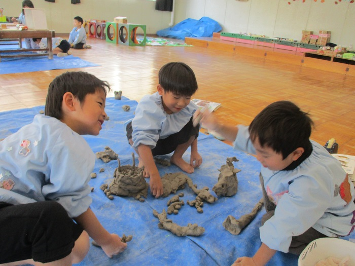 子どもたちがつくった土粘土で遊んでいる様子