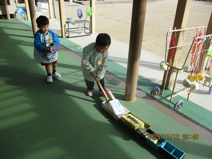 3歳児が箱でつくった車を走らせて遊んでいる様子