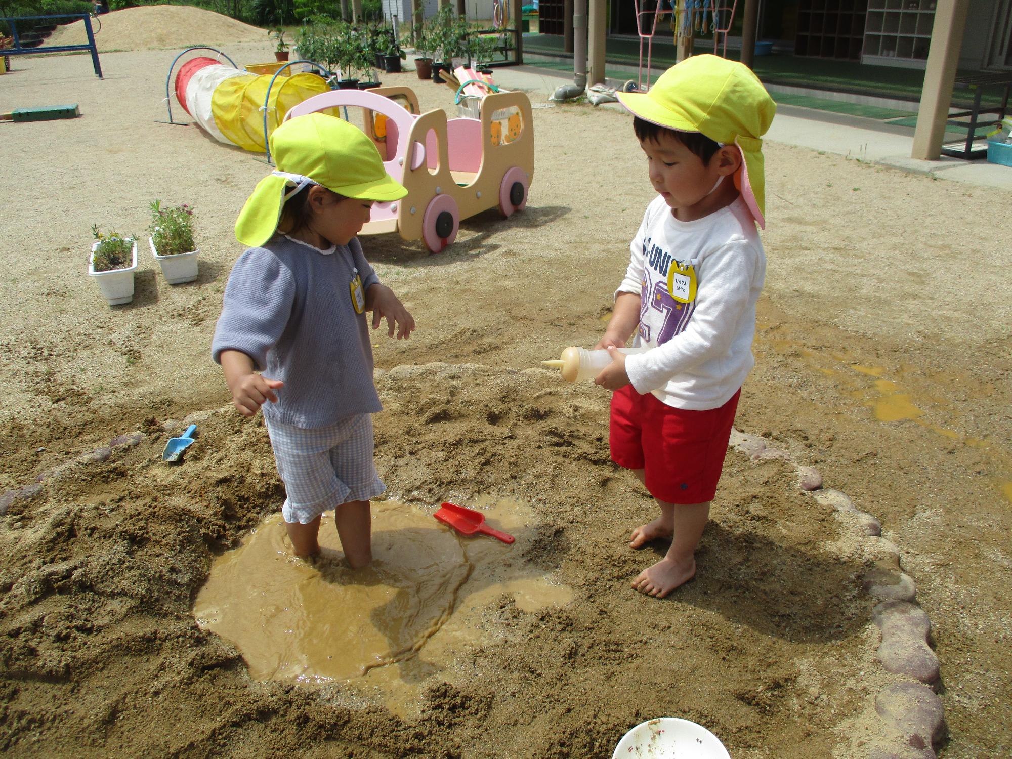 3歳児が砂場で遊んでいる様子