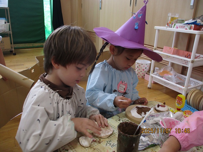 ドングリなどを使ってクッキーをつくる4歳児の様子
