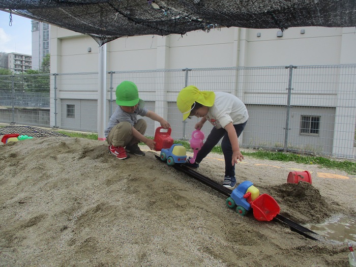 3,4歳児が一緒に砂場で遊ぶ様子