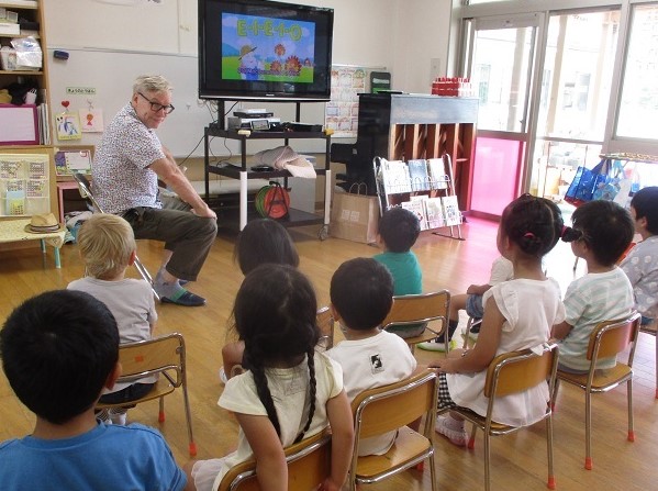 英語の先生と一緒に英語の歌で遊ぶ子どもたち