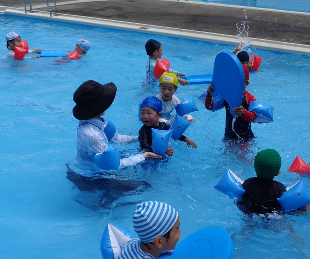小学校のプールで水遊びを楽しむ子ども達の様子