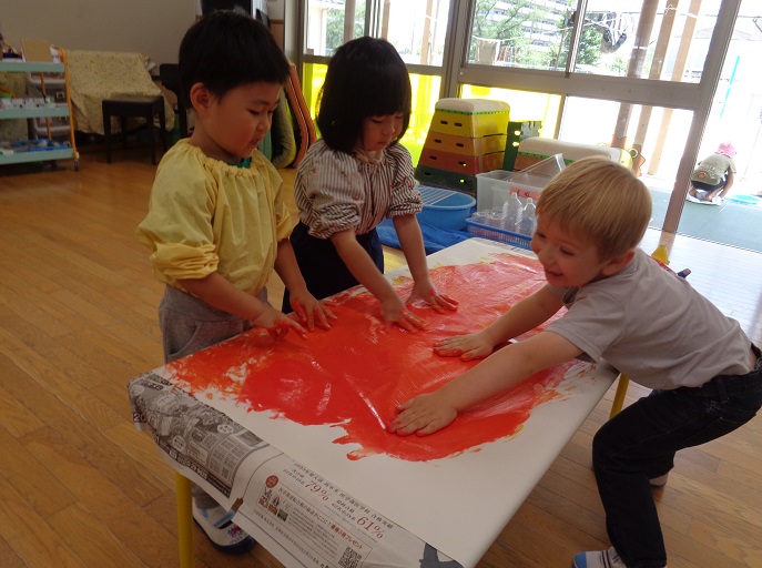 指絵の具で遊ぶ3歳児の様子