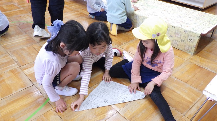 5歳児が4歳児に兜折り方教えている