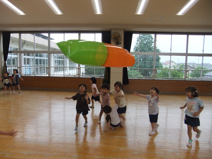 大きな風船で友達と遊んでいる様子