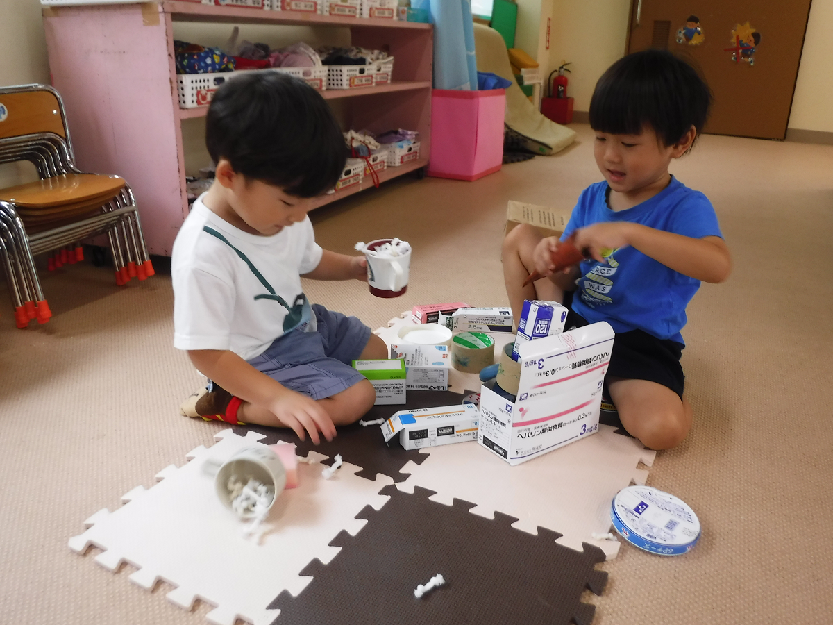 子どもが空き箱に廃材を沢山詰め込んで遊んでいる様子