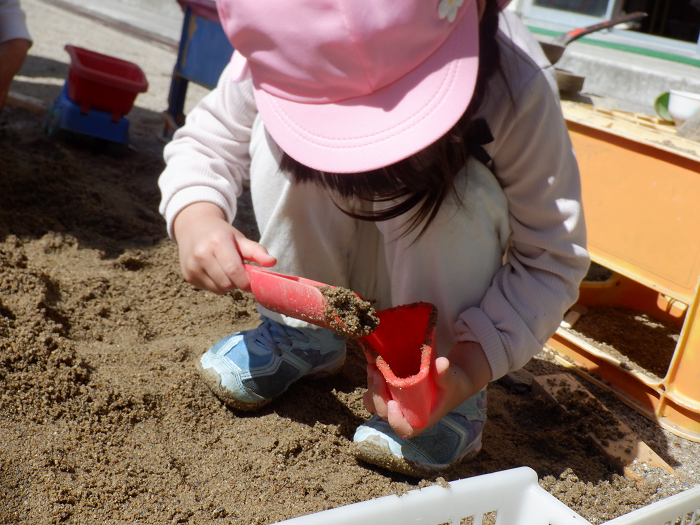 3歳児　砂を使ってケーキをつくっているところ
