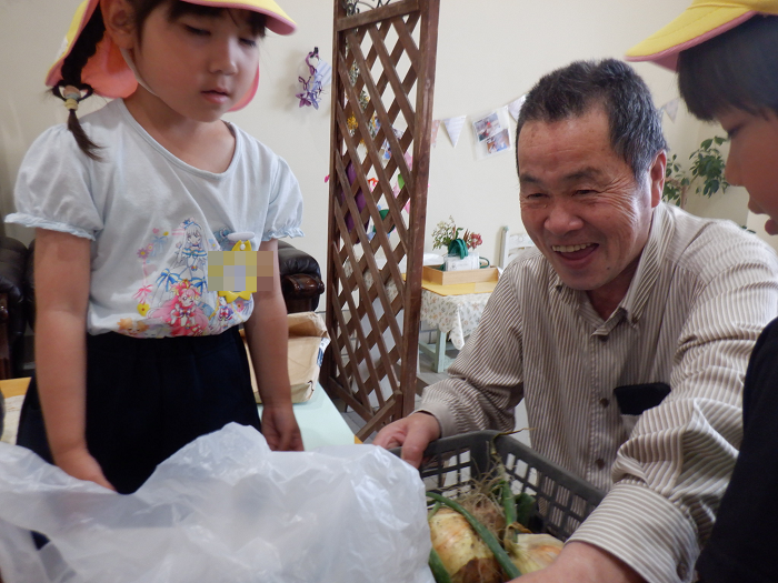 5歳児　育てたたまねぎを地域の子ども食堂さんへお渡ししているところ