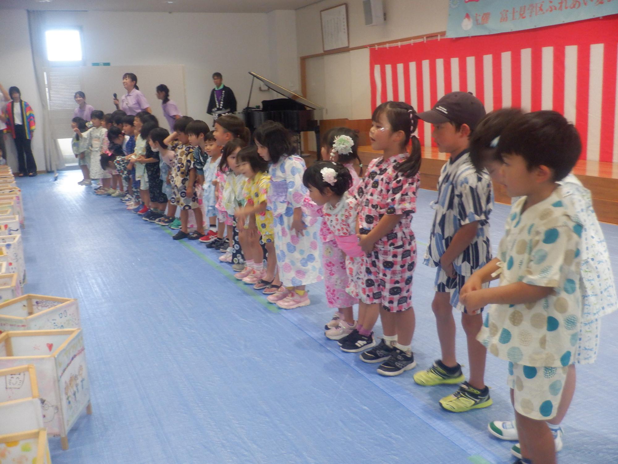 地域の夏祭りで歌を披露する子ども達