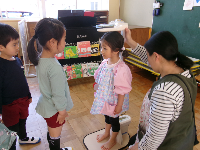3歳児の計測を見守る5歳児