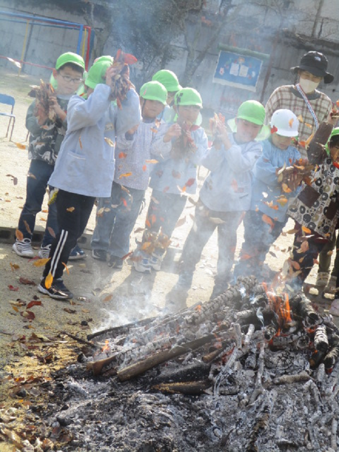 落ち葉を入れる5歳児