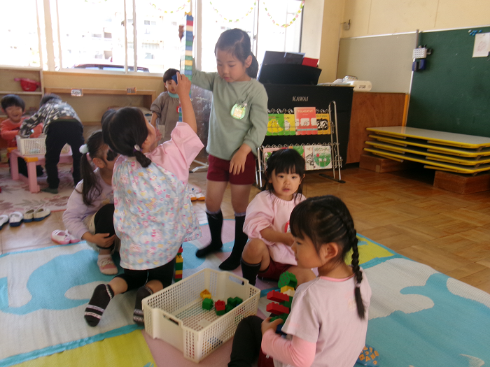 一緒にブロックをする3歳児と5歳児