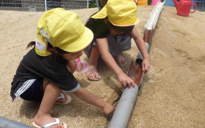 どうやったらながれるかな　樋のつなぎ方を考えている5歳児