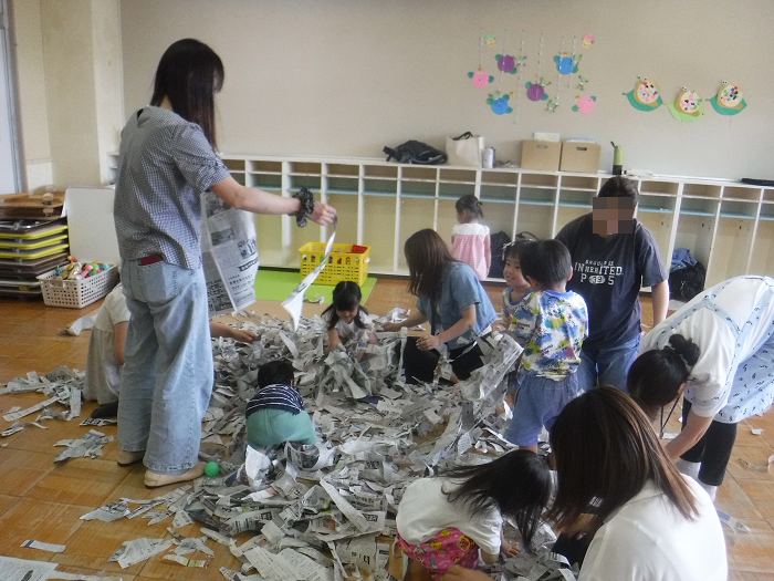 新聞紙を細かくし、あそんでいる様子