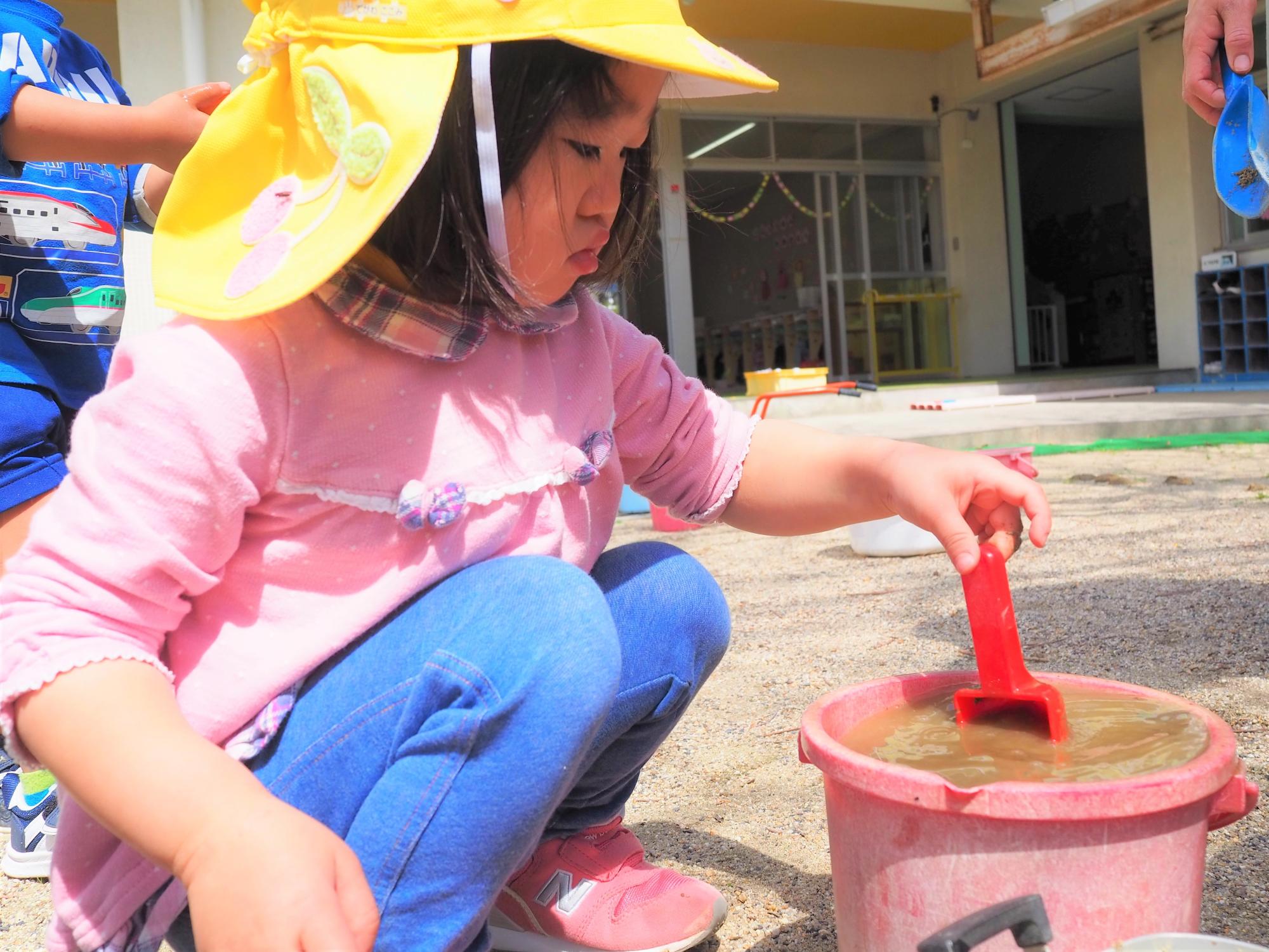 砂や水で遊んでいる子ども