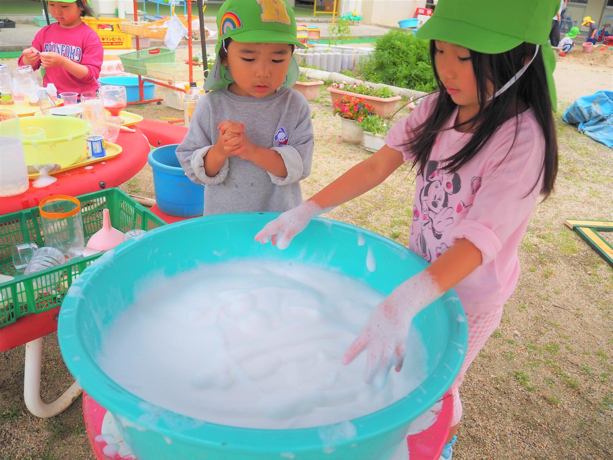 泡で遊ぶ子ども