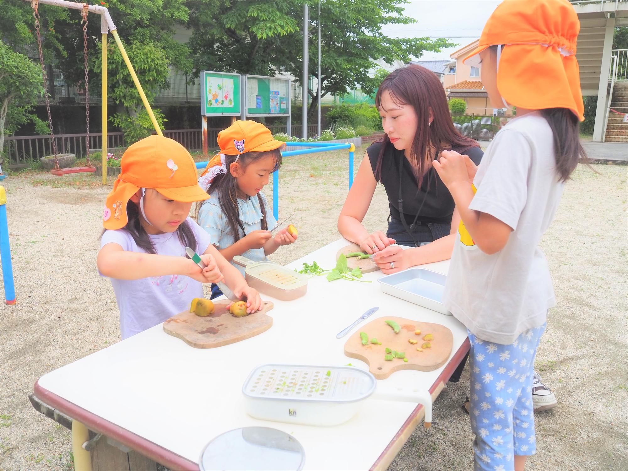 保護者と一緒に飯事で遊んでいる子どもたち