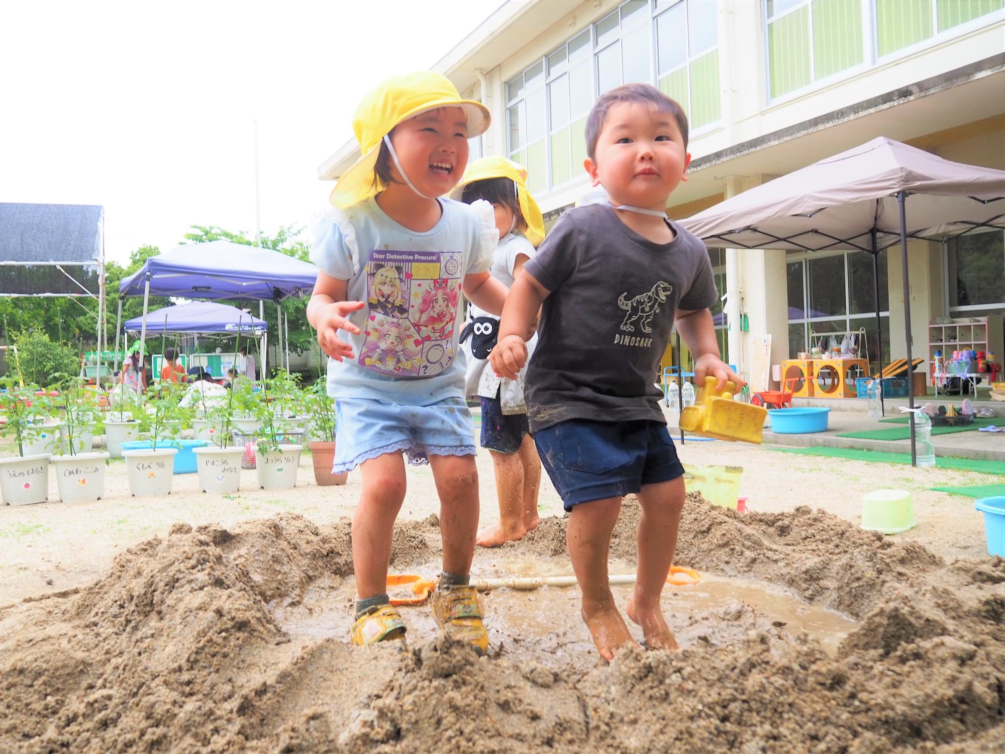 砂場で跳び跳ねている子ども