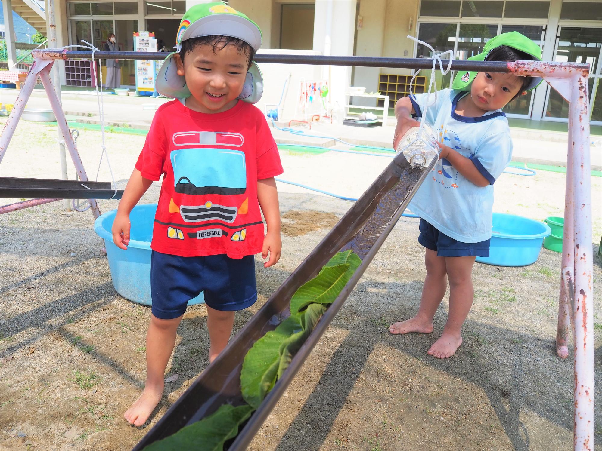 水流しで遊ぶ子ども