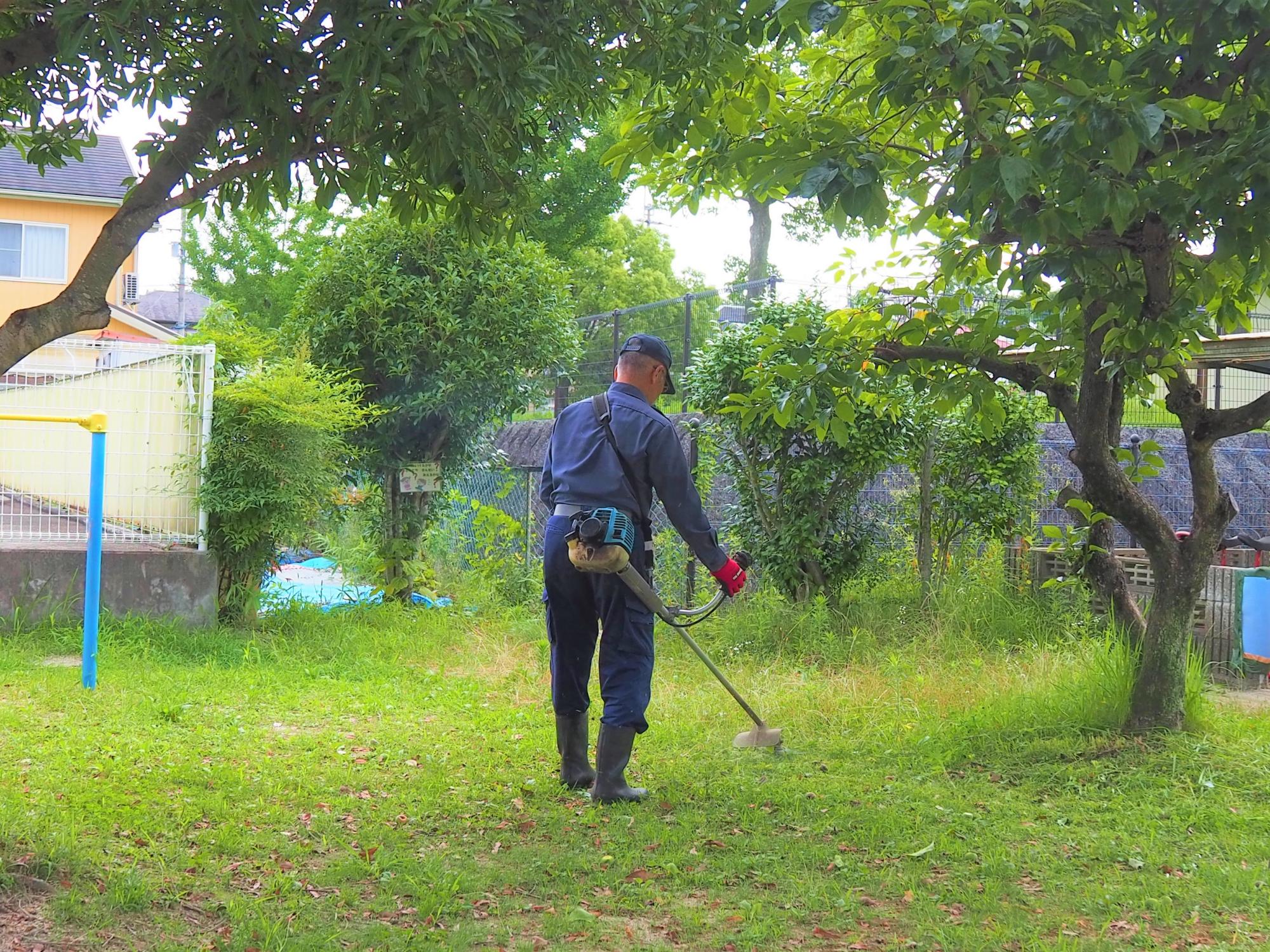 草刈りをする男
