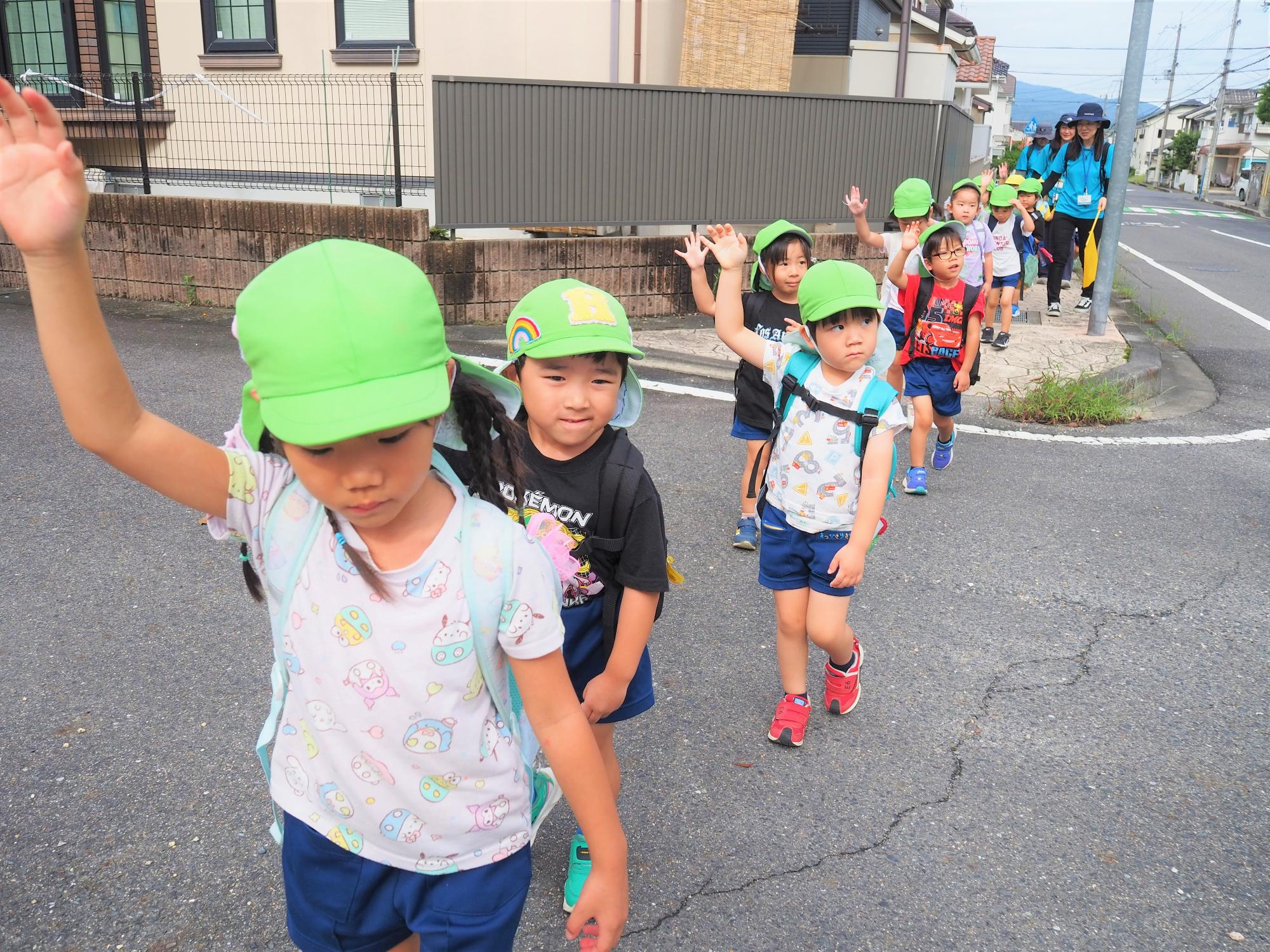 道路で手を挙げて渡る4歳児